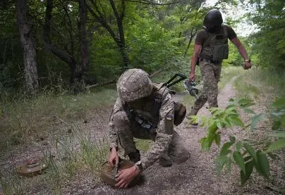 Ukrainian soldiers lay anti-tank mines on a forest road on the Russian troops' potential way in the Donetsk region, Ukraine, in June 2022.